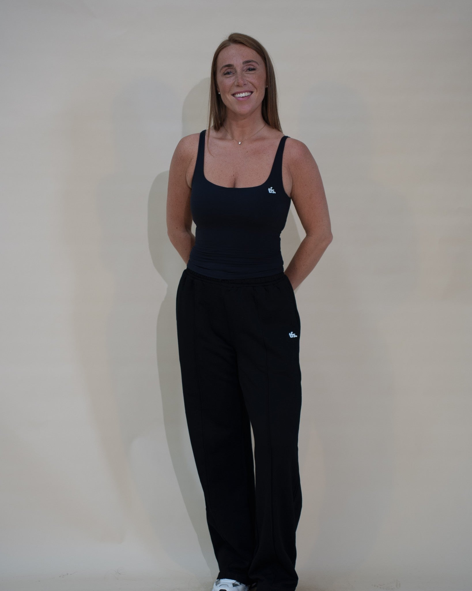 The Uniform Pants — pantalon large femme The Fit Society, noir, de face