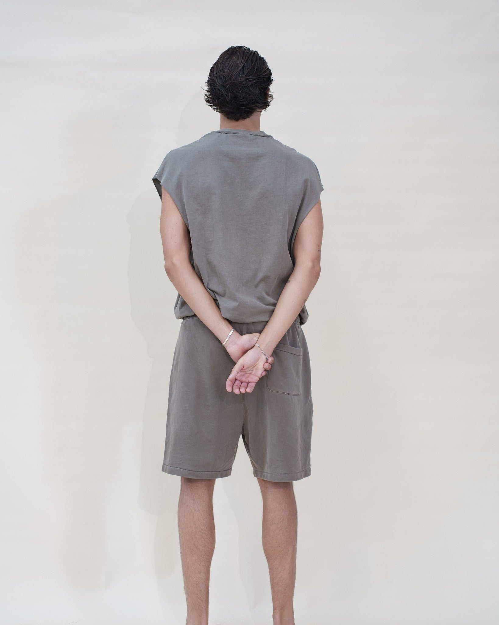 Ensemble Tank Set The Fit Society — The Tank Set Top et The Tank Set Short, homme, café, de dos, mains croisées