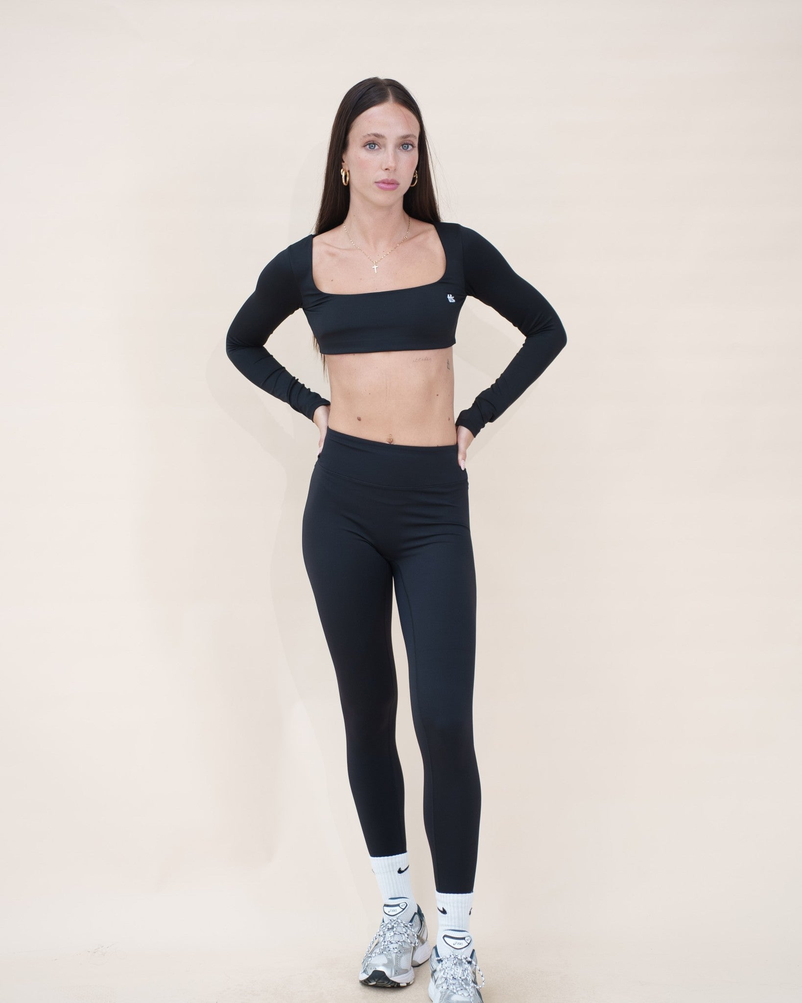 Le vestiaire Studio The Fit Society — haut noir porté avec The Studio Legging, de face