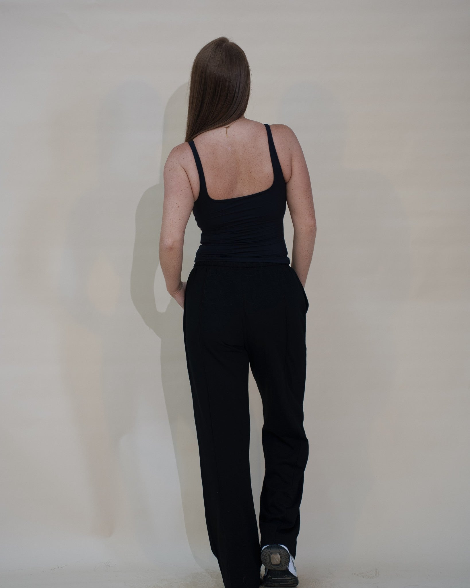 The Uniform Pants — pantalon large femme The Fit Society, noir, de dos