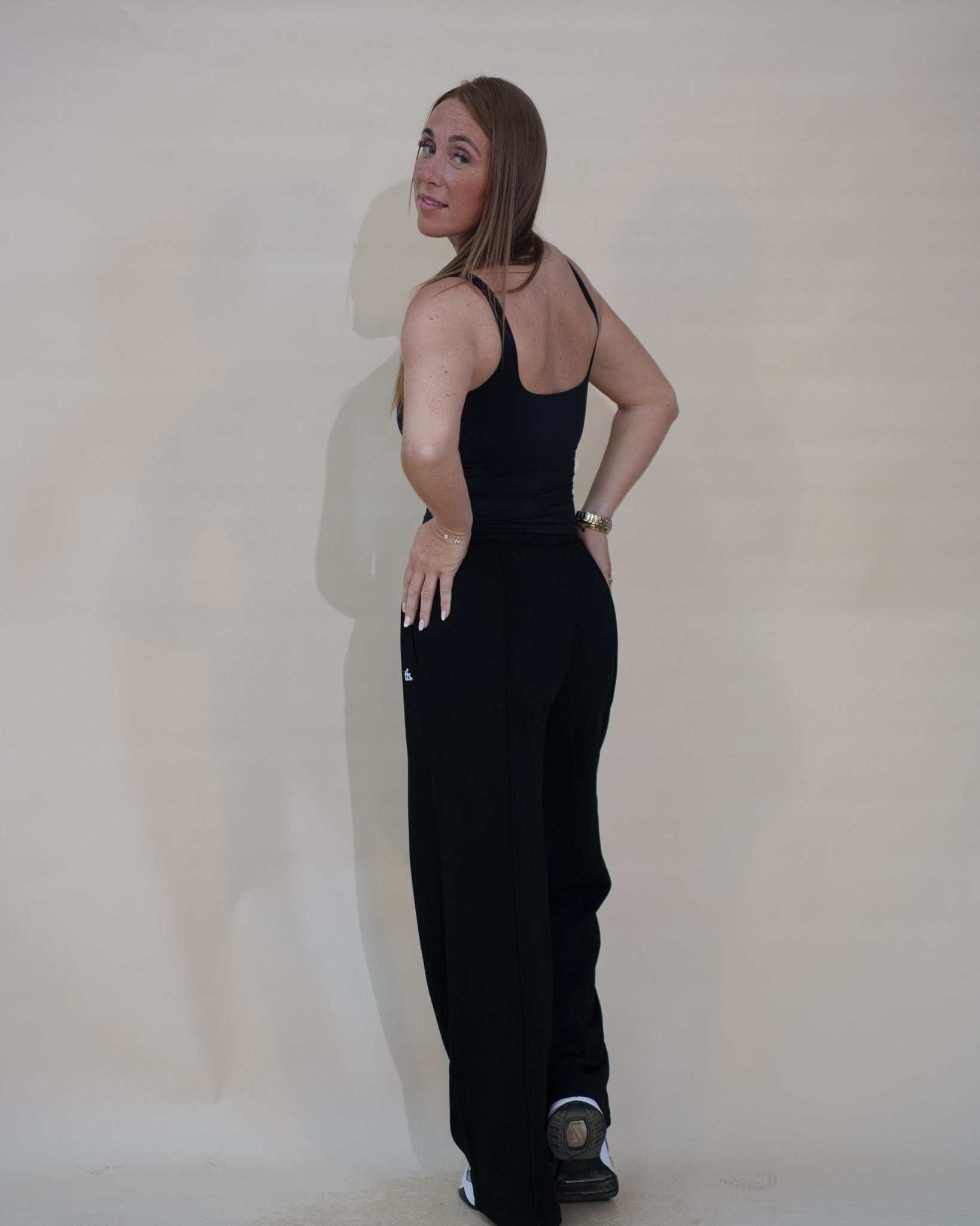 The Uniform Pants — pantalon large femme The Fit Society, noir, trois quarts